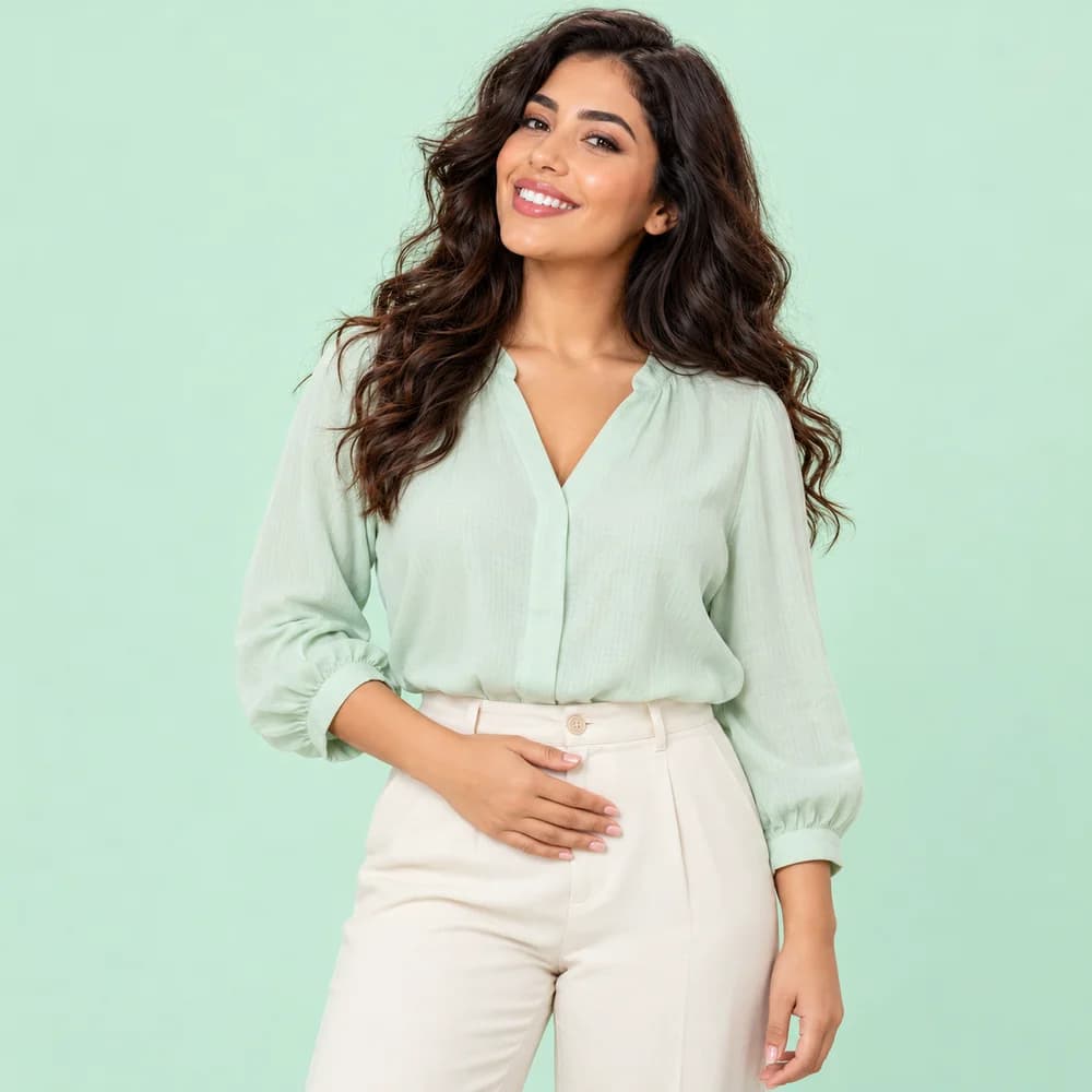 Notre modèle en tenue de coton, la main sur le bas du ventre